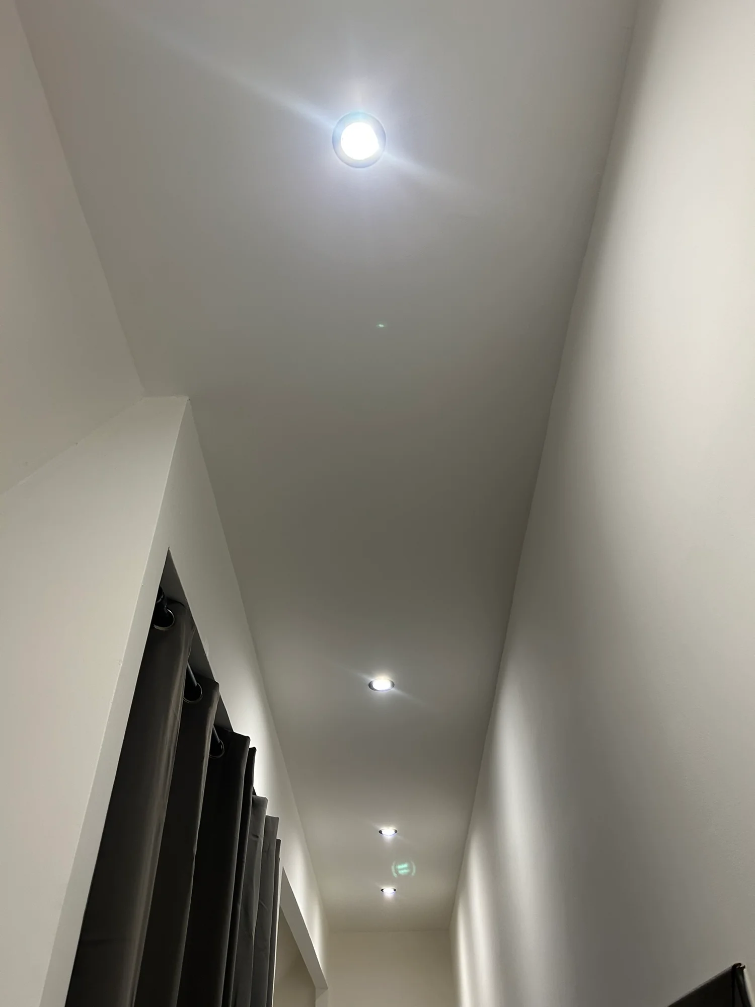 Spots encastrés alignés dans le plafond d’un couloir