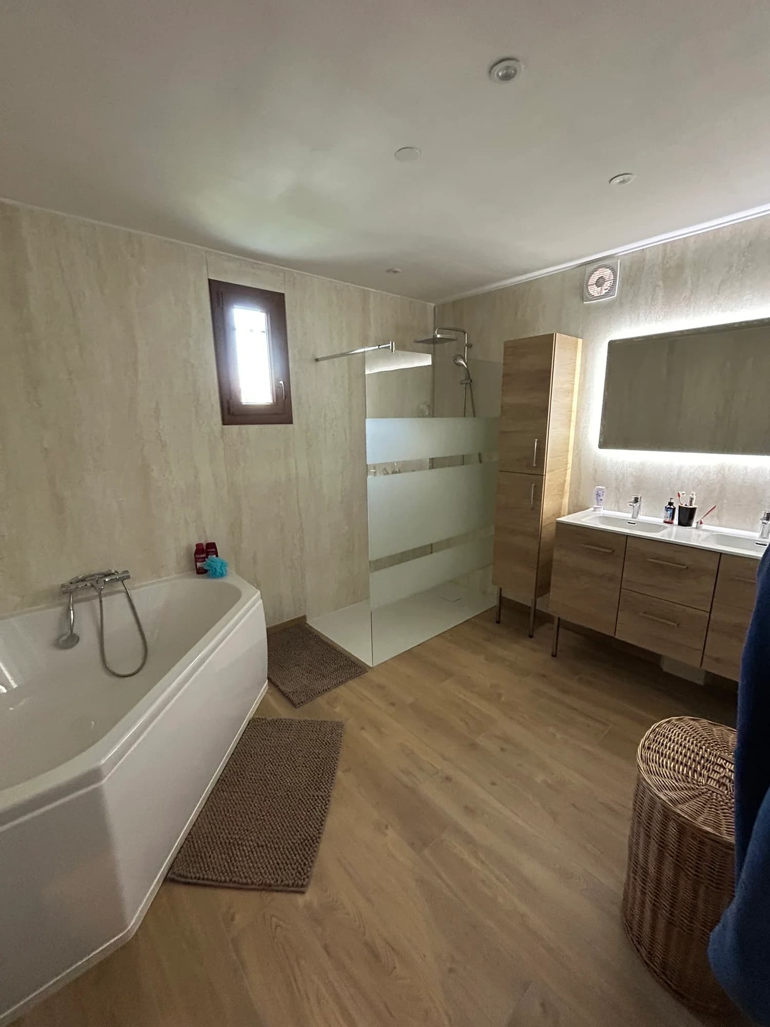 Salle de bain avec baignoire, douche vitrée et meuble double vasque